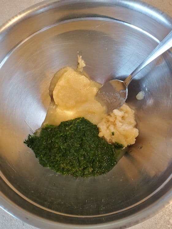 Applesauce, mashed banana, and spinach puree in a metal bowl.