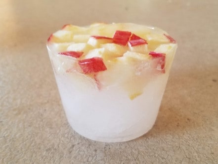 Ice with apples frozen in it.