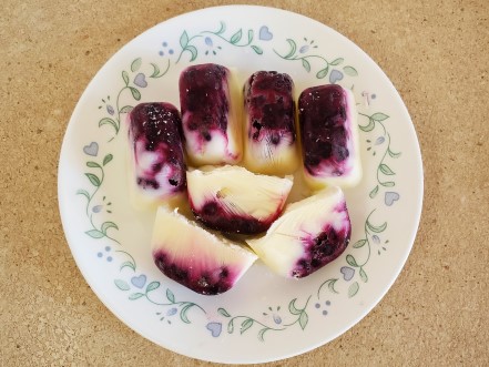 Frozen blueberry treats with blueberries and then Greek yogurt on top.