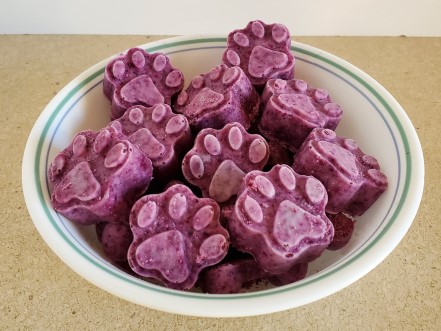 Paw shaped frozen blueberry dog treats.