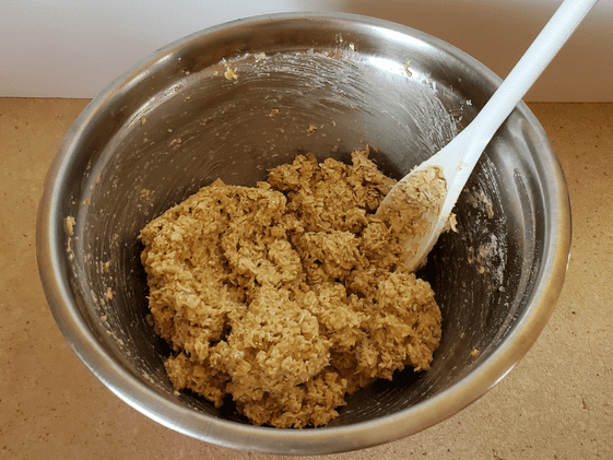 Oatmeal, applesauce, and peanut butter mixed in a bowl.