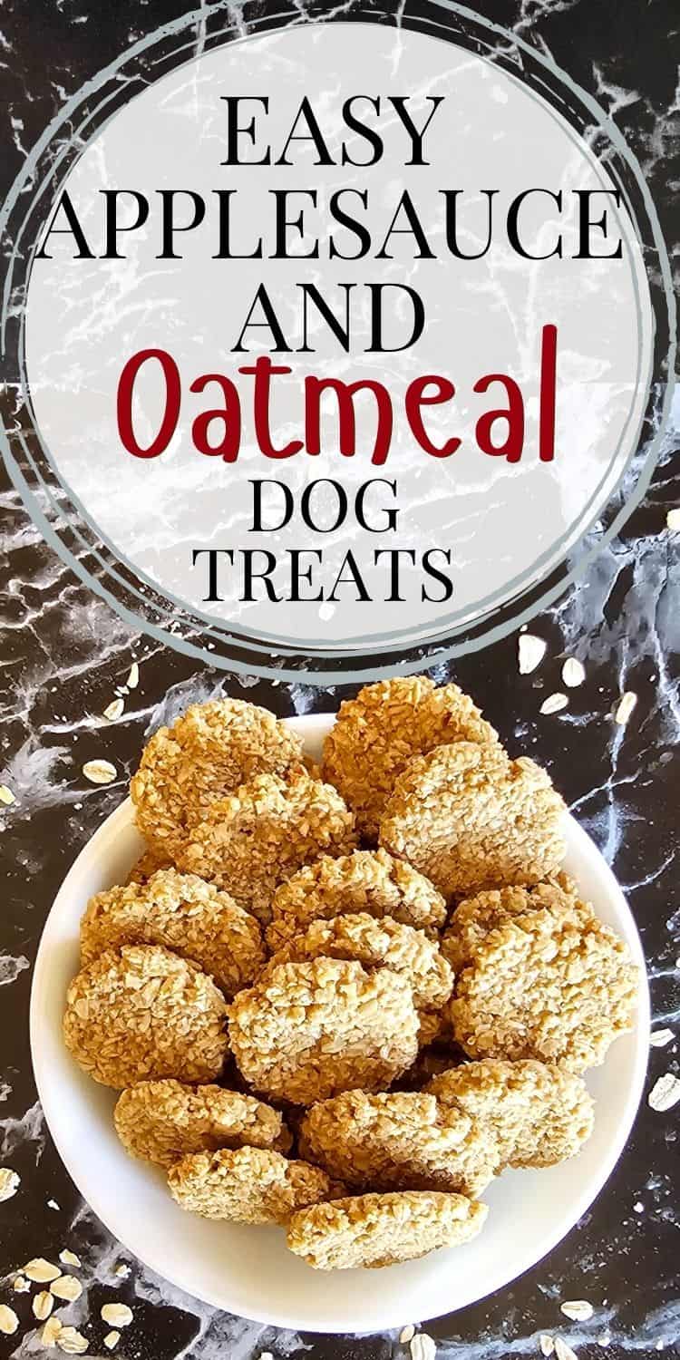 A white plate holds a pile of round, golden-brown oatmeal and applesauce dog treats, set against a black surface with scattered oats, highlighting an easy homemade recipe for healthy dog snacks.
