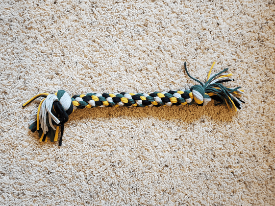DIY t-shirt tug toy made from green, yellow, black, and gray t-shirts.