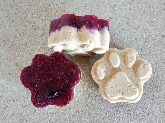 3 paw print shaped peanut butter and jelly dog treats.