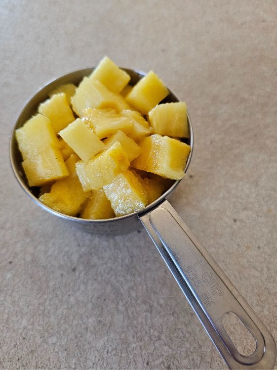 A cup of chopped pineapple.