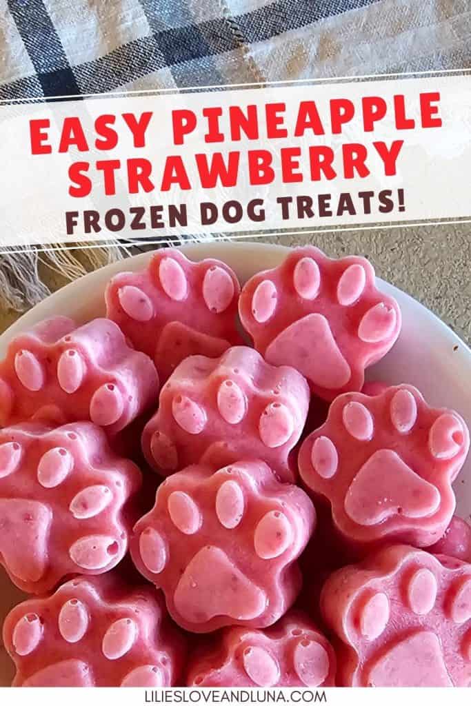 A bowl filled with pink, paw-shaped frozen dog treats made from pineapple and strawberry, suitable for summer and easy homemade dog treats.