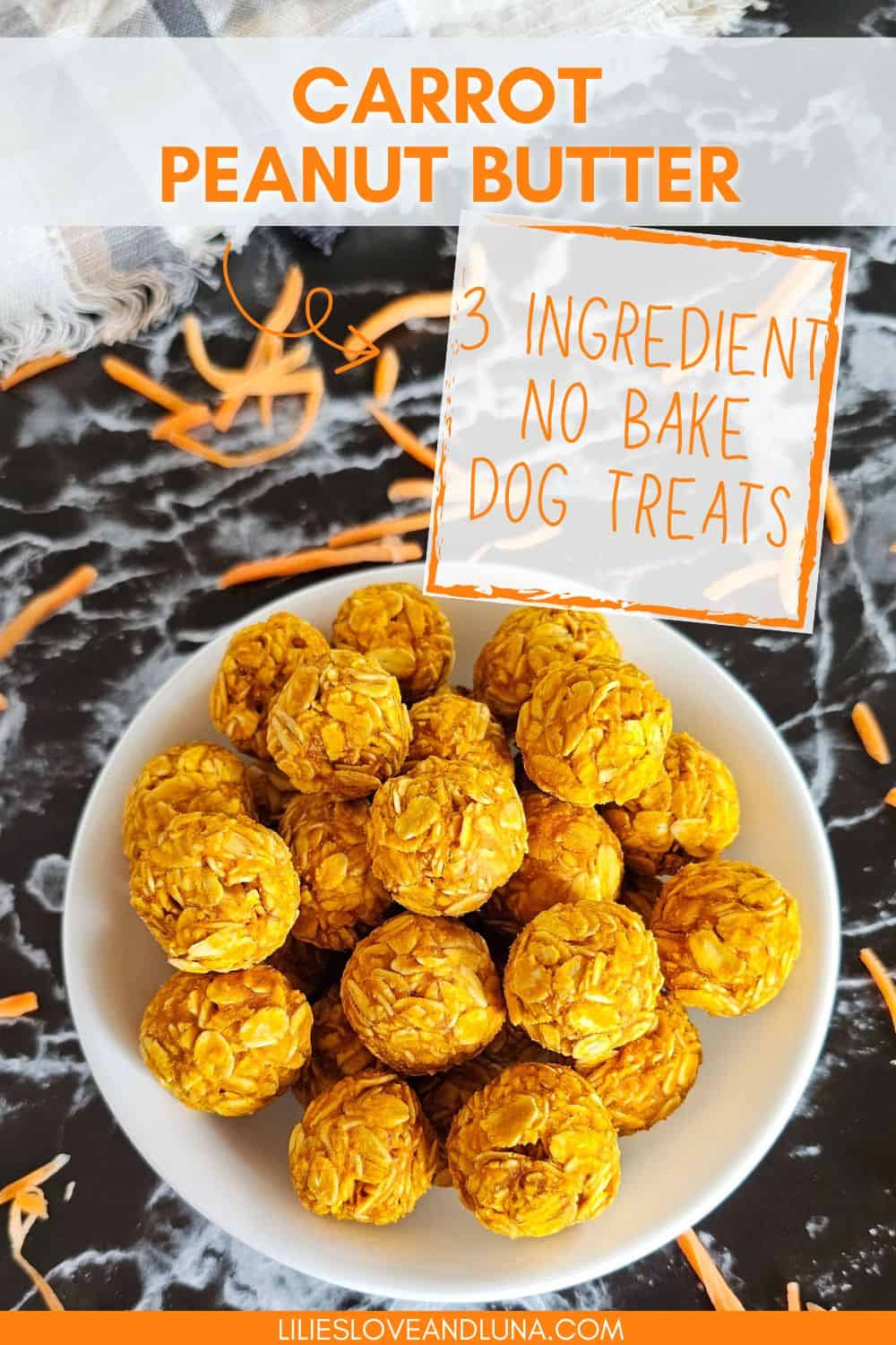 A bowl of round, no-bake dog treats made from carrots and peanut butter is surrounded by scattered carrot shavings on a dark surface.