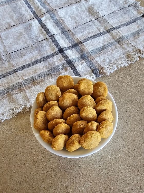 Sweet potato pumpkin dog treats in a white bowl next to a linen towel.