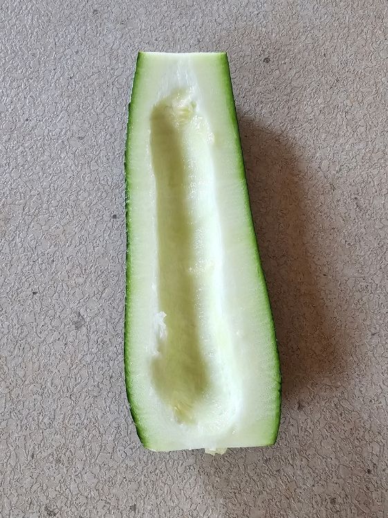 A zucchini cut in half with seeds removed.