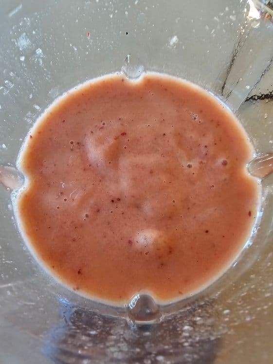 Strawberry mango banana puree in a blender.