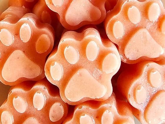 Closeup of paw shaped strawberry mango banana frozen dog treats.