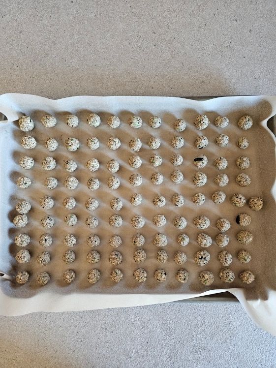 A cookie sheet filled with zucchini banana balls ready for the fridge.