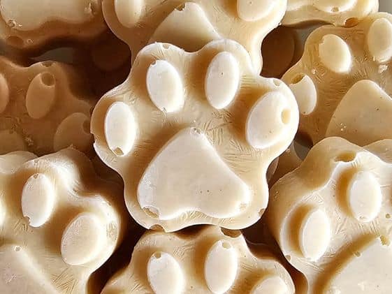 Close up of paw shaped peanut butter and zucchini frozen dog treats.