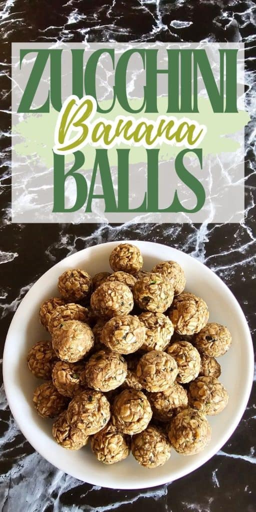 A white bowl filled with homemade zucchini and banana balls, made from oats and peanut butter, sitting on a black marble surface.